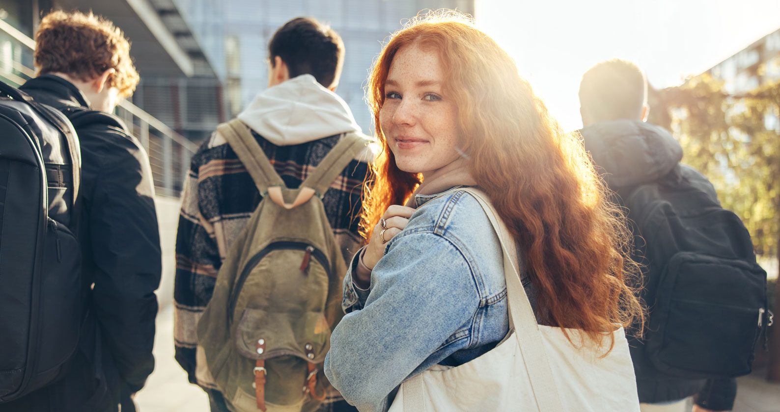 Woman smiling at the camera while her companions face away.