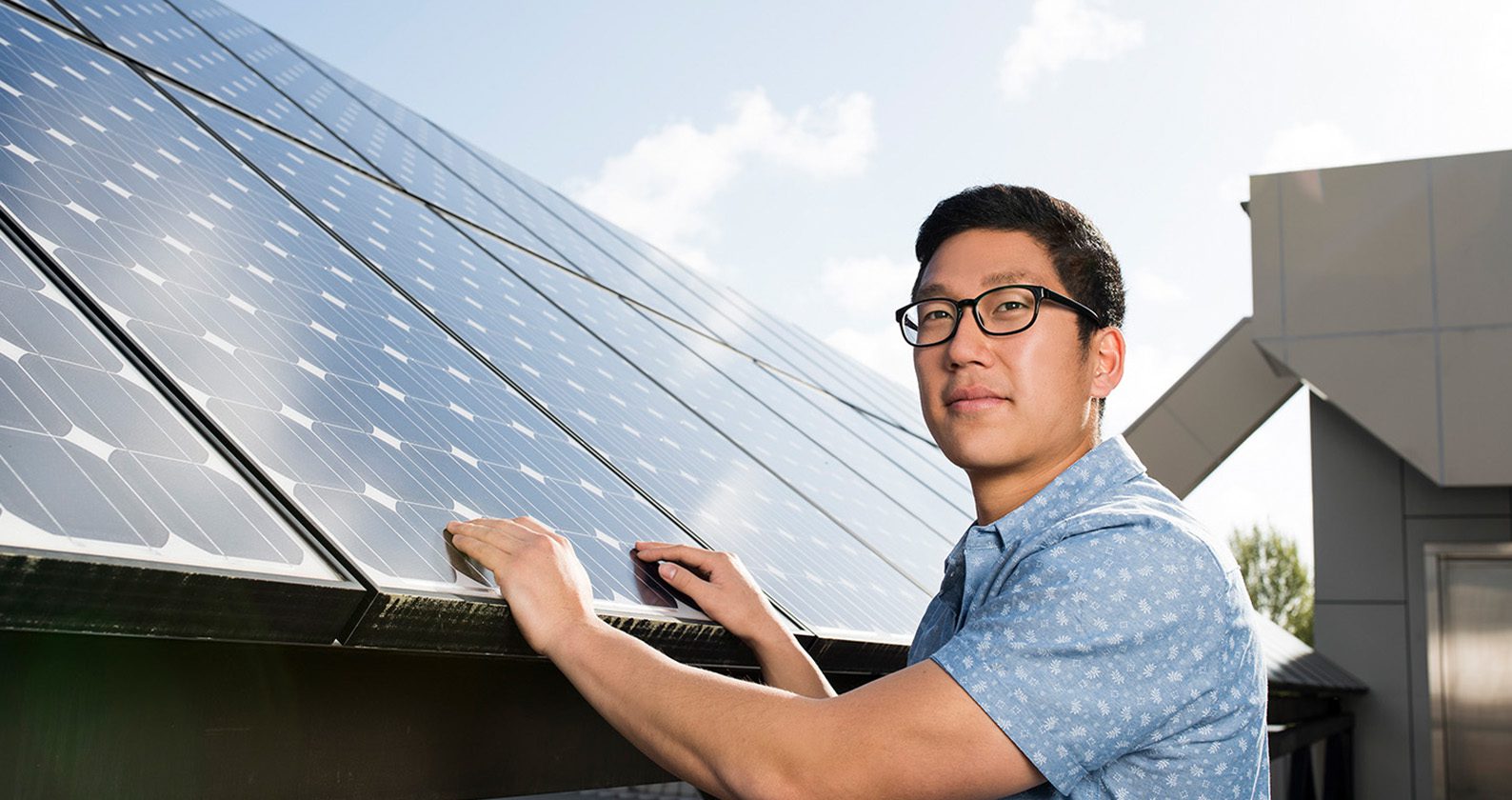 A person touching a solar panel.