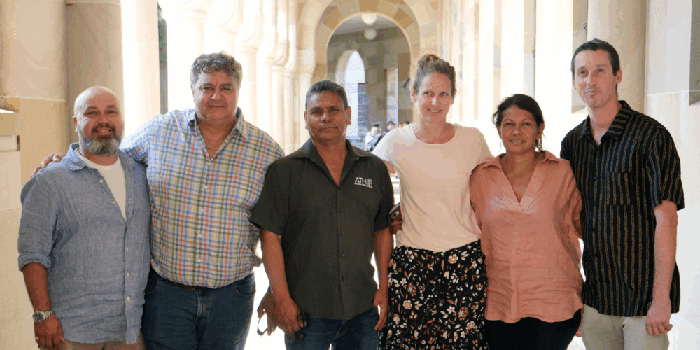 Six members of the Indigenous Reference Group for Threatened Species Recovery Hub standing in a line