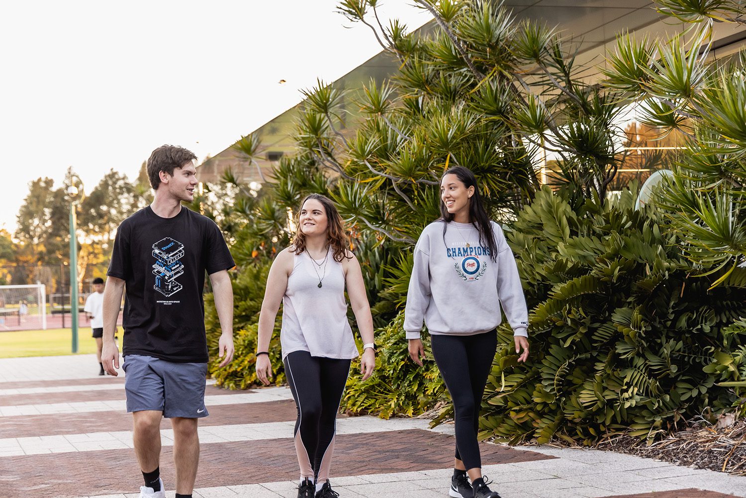Three students walking towards Curtin Stadium