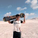 Image of Musa holding a sand board at the sand dunes in Lancelin