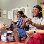 Four students sitting and laughing in Curtin accommodation
