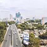 Aerial shot of Surabaya cityscape showcasing roads, buildings, and greenery.