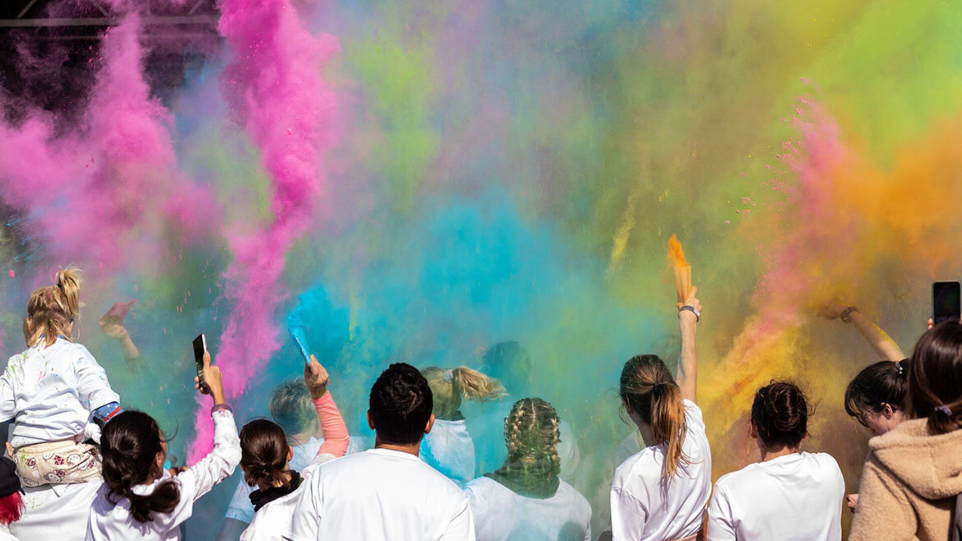 People participating in the colour run with colour powder around them