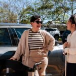 two students with disability chatting at a parking lot