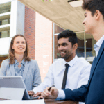 Three students in business attire chatting