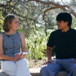 Musa and Bianca sitting at the Yarning Circle while learning Noongar language together.
