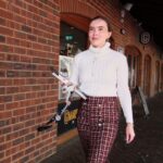 Woman on right side of image walking purposefully forward with a smile.
