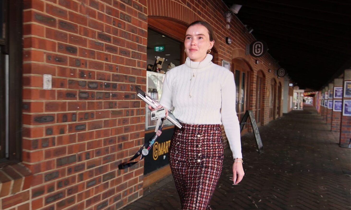 Woman on right side of image walking purposefully forward with a smile.