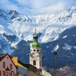 Image of a steeple with mountains at the background.