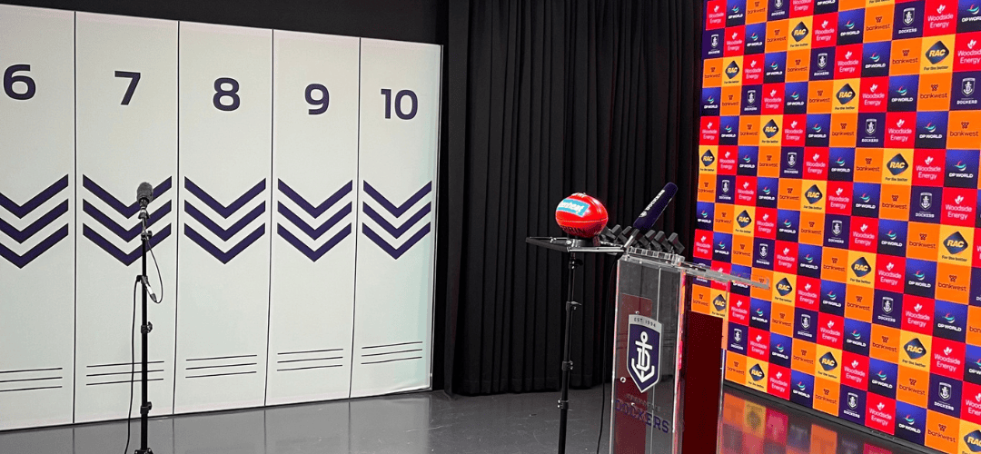 Fremantle Dockers media room with microphones, lighting equipment and a lectern.