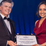 Award recipient holding a technology innovation certificate at an awards ceremony.
