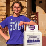 Student standing beside a campus period product dispenser.