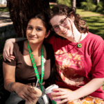 Two female students wearing a sunflower lanyard and pin