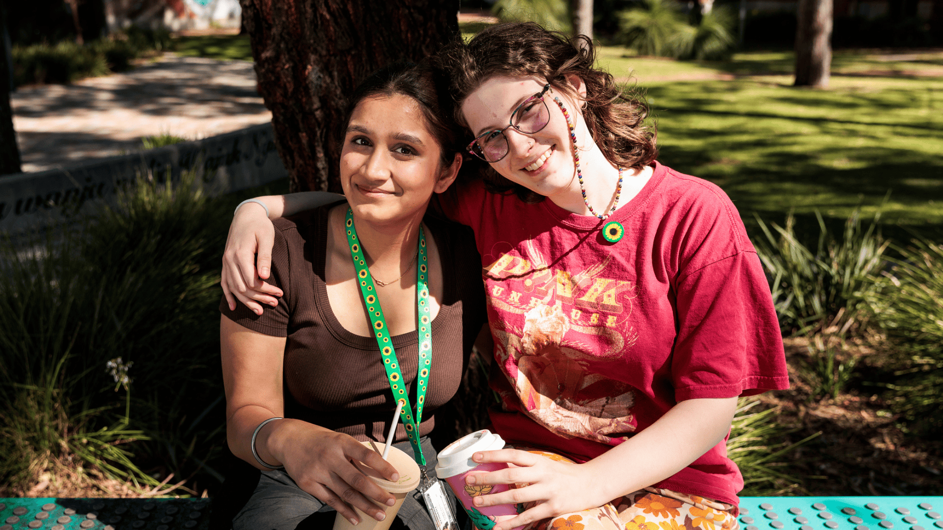 Two female students wearing a sunflower lanyard and pin