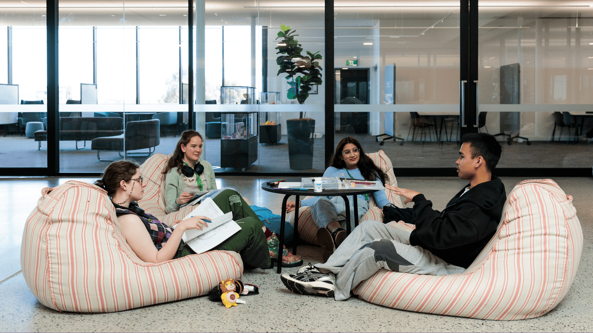 Four students sitting down and facing each other to discuss