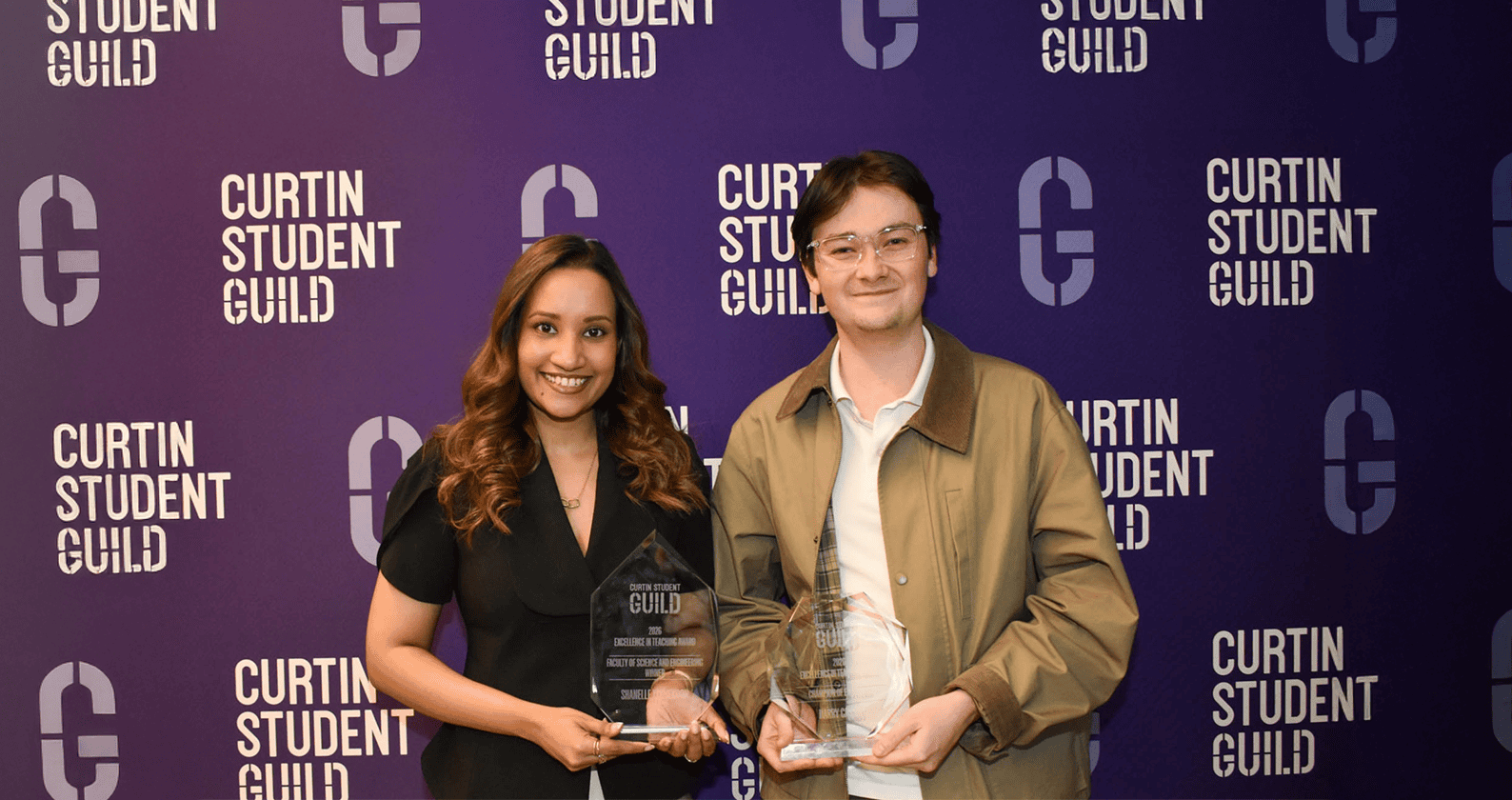 Two award recipients holding Excellence in Teaching Awards.