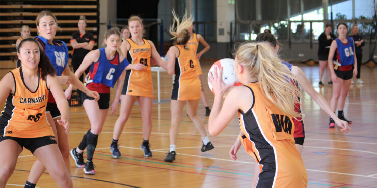 Students playing netball on indoor courts