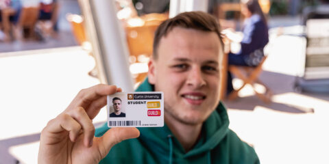a male student showing his student ID card