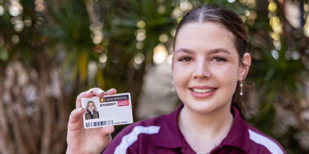 Lady holding a student ID outdoors