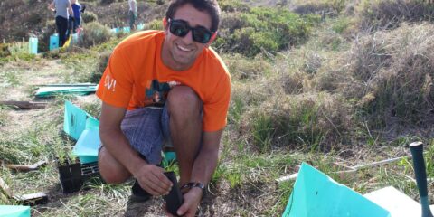 a curtin volunteer student putting something in the ground