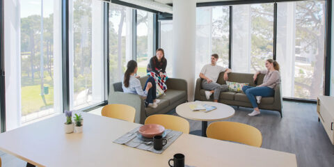 students sitting on couches in an apartment