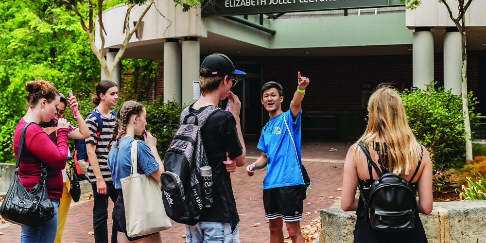 A student mentor gives a campus tour to new students