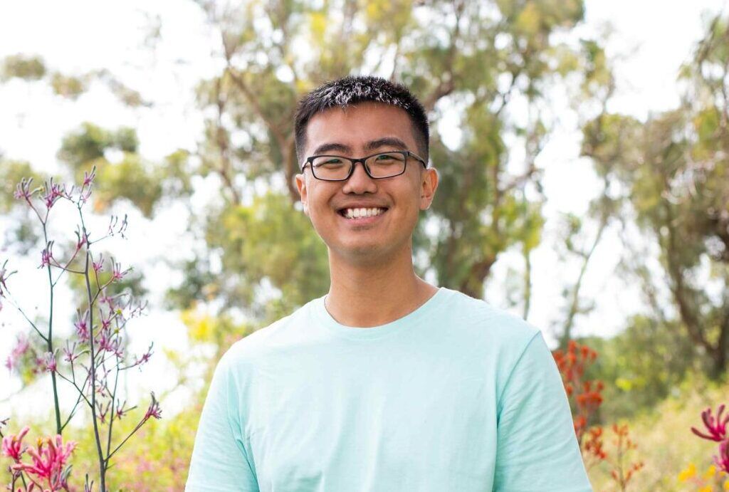 student smiling in front of trees