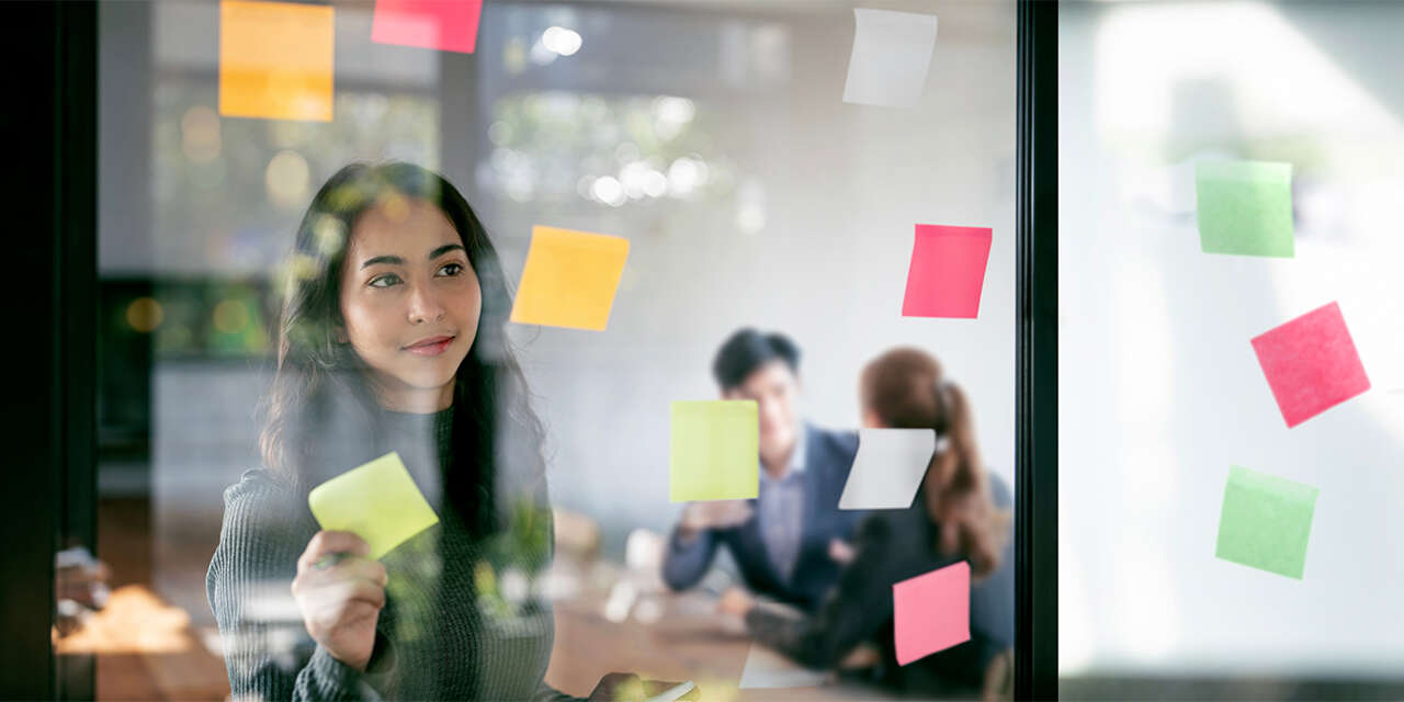 Female student placing sticky notes on window