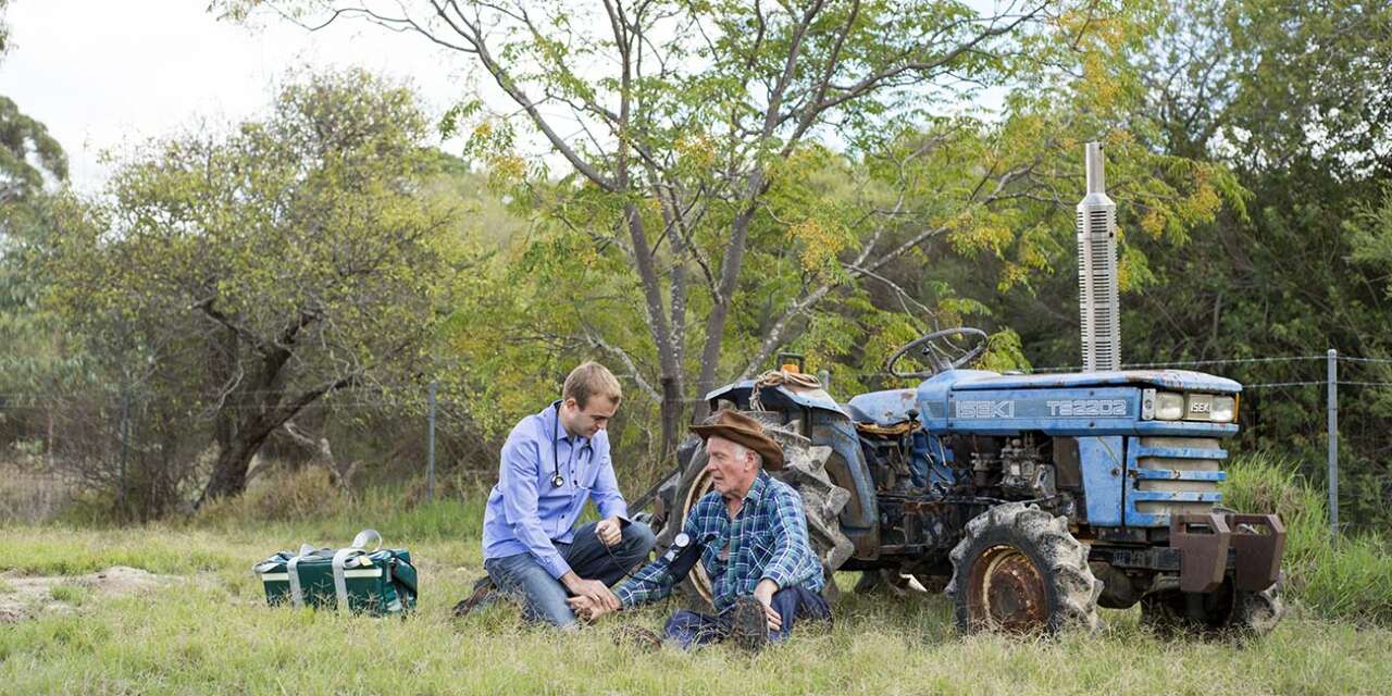 Medical student in a field helping injured man