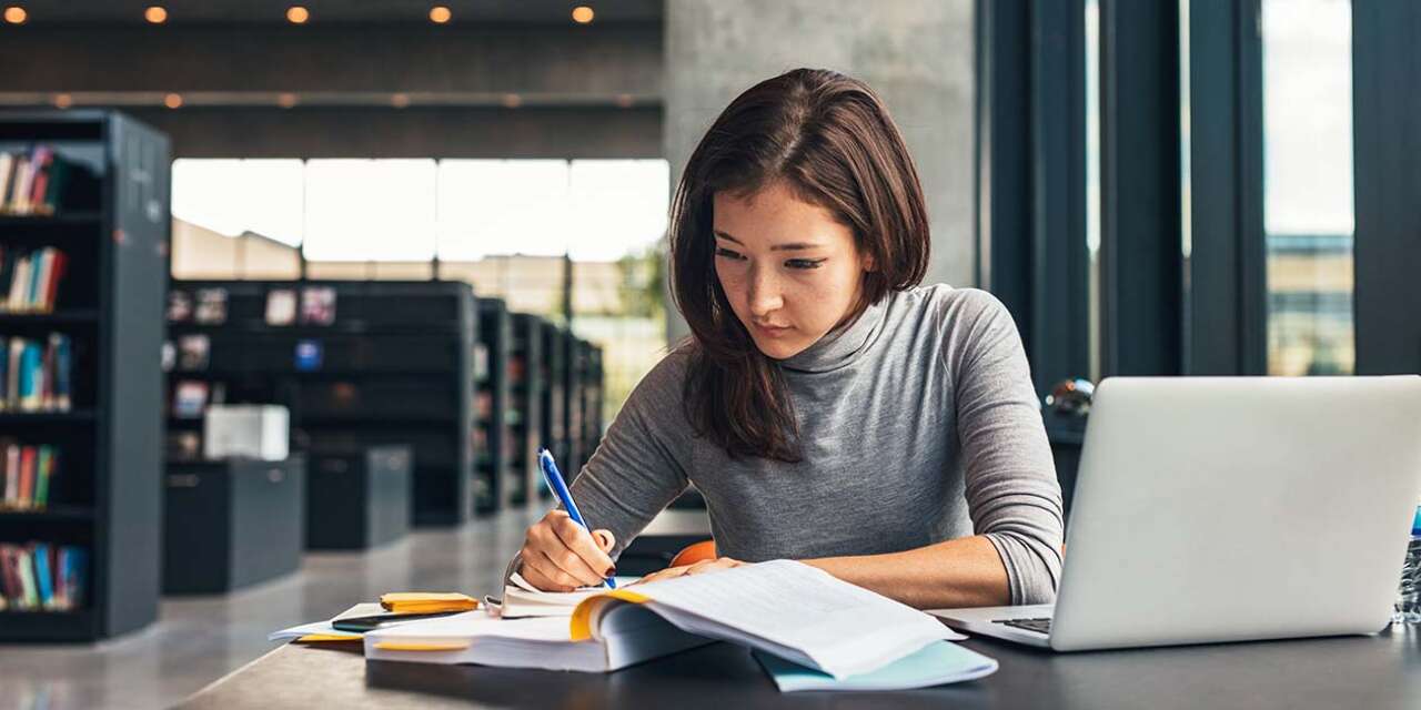 Girl studying at library desk