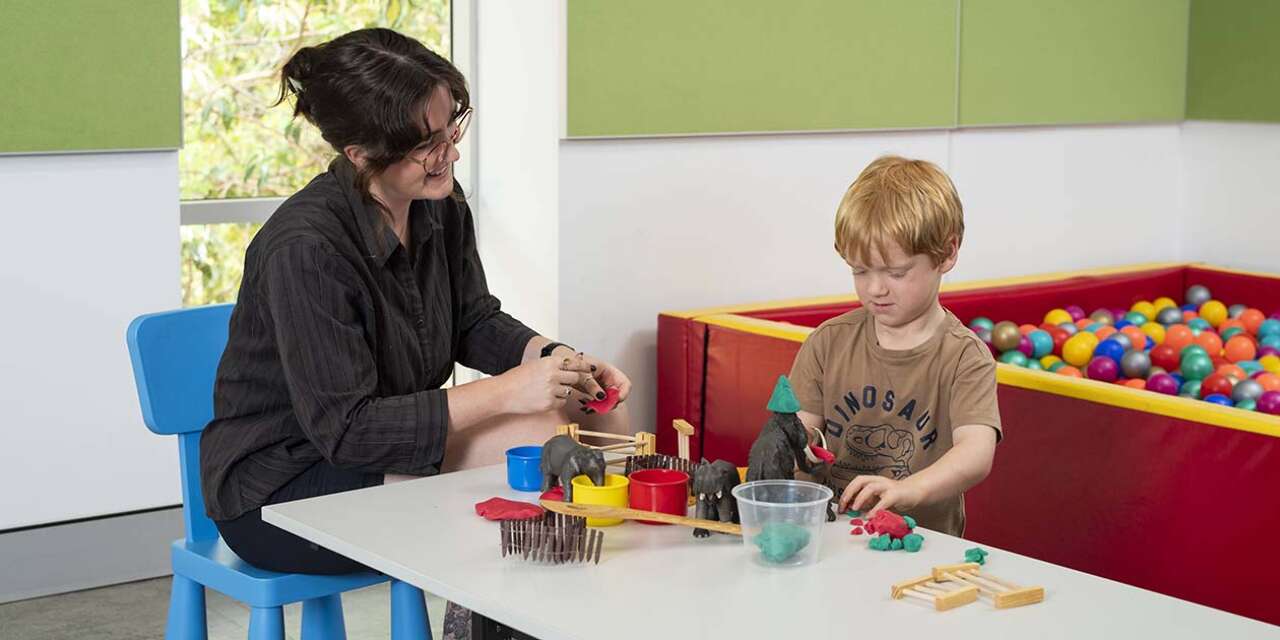 Social work student in workplace setting with two children