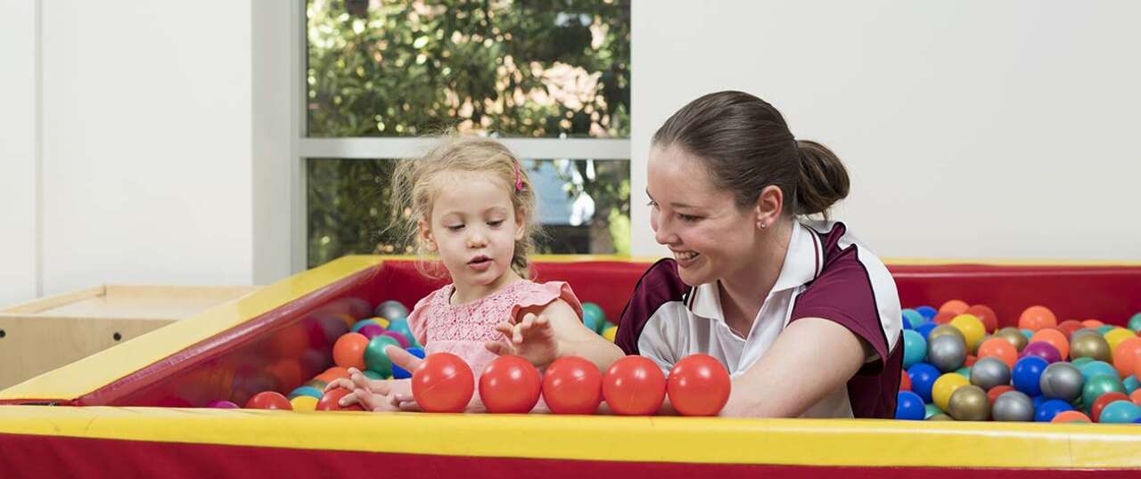 OT student in ball pit with child