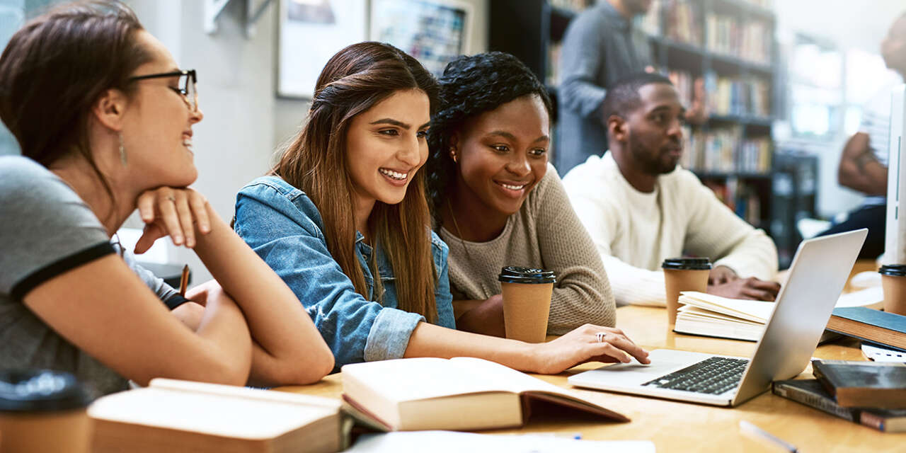 Students looking at a laptop during a meeting