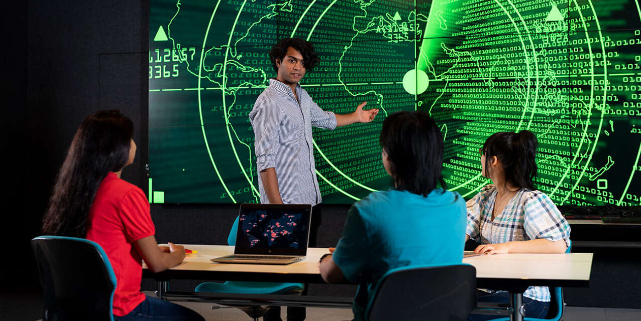 Educator pointing at a map with green data points everywhere.