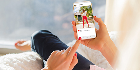 Woman looking at photo sharing app on mobile phone