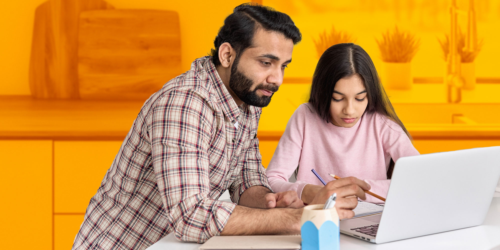 Father and daughter sitting at a lap top